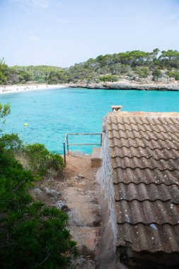 Güzel gün batımı plaj manzarası, egzotik tropik ada doğası, mavi deniz suyu, okyanus dalgaları, renkli kırmızı gökyüzü, Mallorca, İspanya 'da yaz tatili