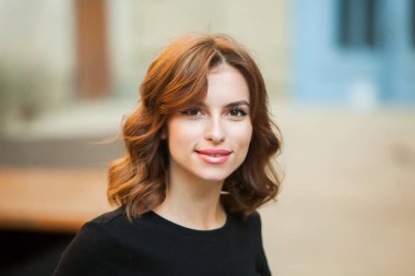 Gülümseyen ve kameraya bakan güzel bir genç kadının portresini yakından çek. Güzel gülüşlü beyaz Avrupalı kız