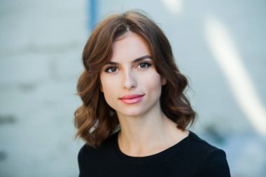 Gülümseyen ve kameraya bakan güzel bir genç kadının portresini yakından çek. Güzel gülüşlü beyaz Avrupalı kız