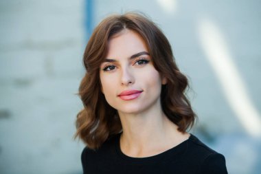 Gülümseyen ve kameraya bakan güzel bir genç kadının portresini yakından çek. Güzel gülüşlü beyaz Avrupalı kız