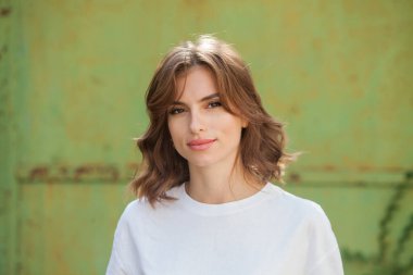 Gülümseyen ve kameraya bakan güzel bir genç kadının portresini yakından çek. Güzel gülüşlü beyaz Avrupalı kız