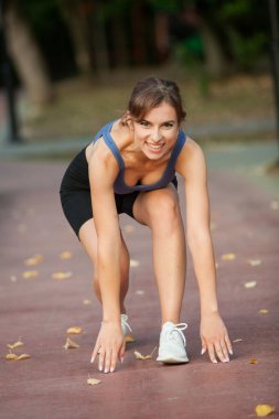 Spor giyimli genç bayan koşmaya hazır.