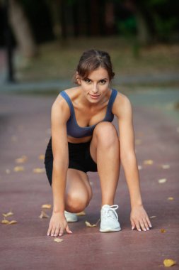 Spor giyimli genç bayan koşmaya hazır.