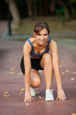 Spor giyimli genç bayan koşmaya hazır.