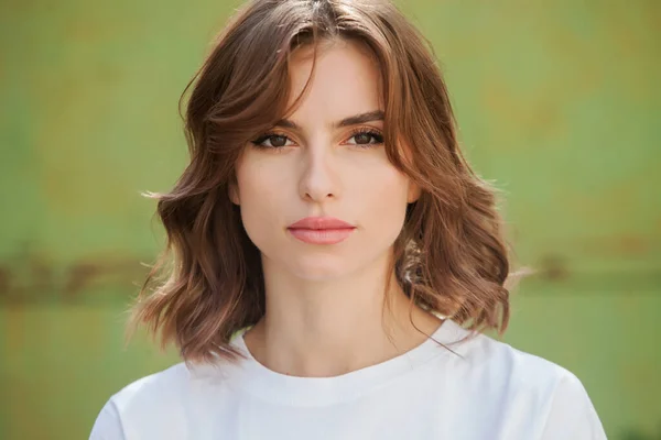 Gülümseyen ve kameraya bakan güzel bir genç kadının portresini yakından çek. Güzel gülüşlü beyaz Avrupalı kız