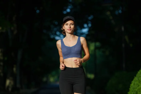 穿着运动服的年轻女子在公园里慢跑 健康和健康的生活方式 一个穿着运动服的年轻漂亮女子的画像 室外体育健身模式高加索族裔培训 — 图库照片