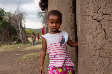 Masai geleneksel renkli giysiler içinde Masai 'nin ünlü Safari seyahat merkezinin yakınındaki yerel bir kabile köyünde dans ettiğini gösteriyor. Kenya. Yazı