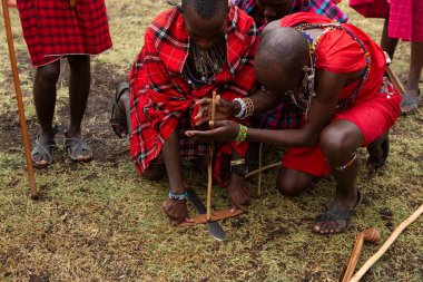 Masai geleneksel renkli giysiler içinde Masai 'nin ünlü Safari seyahat merkezinin yakınındaki yerel bir kabile köyünde dans ettiğini gösteriyor. Kenya. Yazı