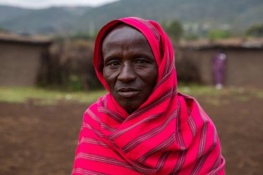 Masai geleneksel renkli giysiler içinde Masai 'nin ünlü Safari seyahat merkezinin yakınındaki yerel bir kabile köyünde dans ettiğini gösteriyor. Kenya. Yazı