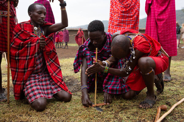 Masai in traditional colorful clothing showing Maasai jumping dance at local tribe village near famous Safari travel destination. Kenya. Editorial
