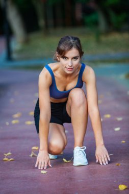 Spor giyimli genç bir kadın parkta koşuyor. Fitness ve sağlıklı yaşam tarzı. Açık havada spor giyimli güzel bir kadının portresi. Spor fitness modeli Kafkasya etnik köken eğitimi.
