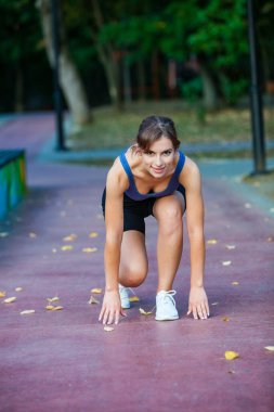 Spor giyimli genç bir kadın parkta koşuyor. Fitness ve sağlıklı yaşam tarzı. Açık havada spor giyimli güzel bir kadının portresi. Spor fitness modeli Kafkasya etnik köken eğitimi.
