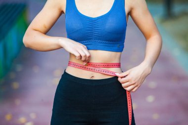 Spor giyimli genç bir kadın parkta koşuyor. Fitness ve sağlıklı yaşam tarzı. Açık havada spor giyimli güzel bir kadının portresi. Spor fitness modeli Kafkasya etnik köken eğitimi.