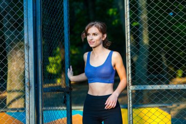Spor giyimli genç bir kadın parkta koşuyor. Fitness ve sağlıklı yaşam tarzı. Açık havada spor giyimli güzel bir kadının portresi. Spor fitness modeli Kafkasya etnik köken eğitimi.