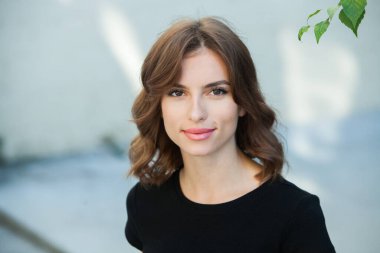 Gülümseyen ve kameraya bakan güzel bir genç kadının portresini yakından çek. Güzel gülüşlü beyaz Avrupalı kız.