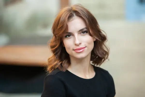 Gülümseyen ve kameraya bakan güzel bir genç kadının portresini yakından çek. Güzel gülüşlü beyaz Avrupalı kız.