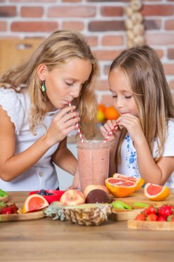 Mutfakta taze sebzelerle iki küçük kız. Sağlıklı gıda konsepti. Mutlu kardeşler..