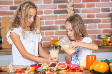 Mutfakta taze sebzelerle iki küçük kız. Sağlıklı gıda konsepti. Mutlu kardeşler..