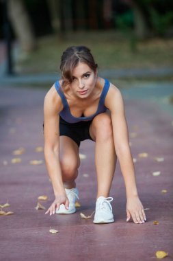 Spor giyimli genç bir kadın parkta koşuyor. Fitness ve sağlıklı yaşam tarzı. Açık havada spor giyimli güzel bir kadının portresi. Spor fitness modeli Kafkasya etnik köken eğitimi.