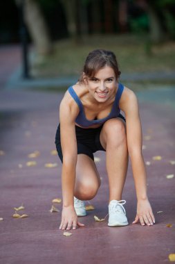 Spor giyimli genç bir kadın parkta koşuyor. Fitness ve sağlıklı yaşam tarzı. Açık havada spor giyimli güzel bir kadının portresi. Spor fitness modeli Kafkasya etnik köken eğitimi.