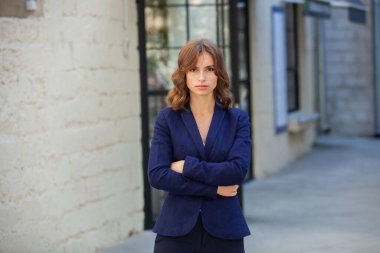 Modern iş binasının önünde başarılı bir iş kadınının portresi. Genç yönetici dışarıda poz veriyor. Ofisin kadın çalışanı..