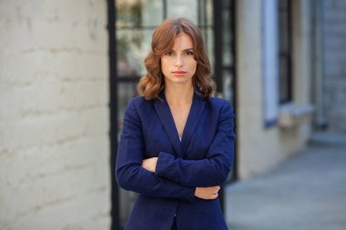 Modern iş binasının önünde başarılı bir iş kadınının portresi. Genç yönetici dışarıda poz veriyor. Ofisin kadın çalışanı..