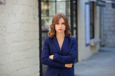 Modern iş binasının önünde başarılı bir iş kadınının portresi. Genç yönetici dışarıda poz veriyor. Ofisin kadın çalışanı..