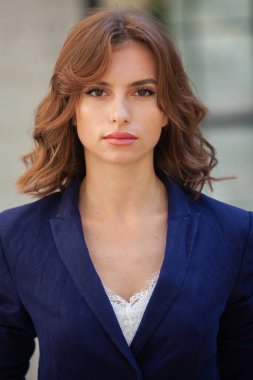 Modern iş binasının önünde başarılı bir iş kadınının portresi. Genç yönetici dışarıda poz veriyor. Ofisin kadın çalışanı..