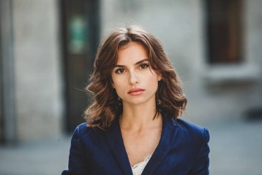 Modern iş binasının önünde başarılı bir iş kadınının portresi. Genç yönetici dışarıda poz veriyor. Ofisin kadın çalışanı..