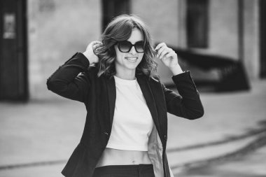 Modern iş binasının önünde başarılı bir iş kadınının portresi. Genç yönetici dışarıda poz veriyor. Ofisin kadın çalışanı..