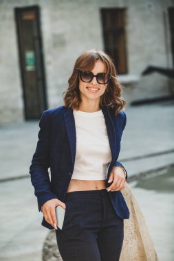 Modern iş binasının önünde başarılı bir iş kadınının portresi. Genç yönetici dışarıda poz veriyor. Ofisin kadın çalışanı..