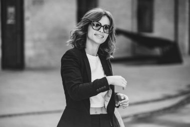 Modern iş binasının önünde başarılı bir iş kadınının portresi. Genç yönetici dışarıda poz veriyor. Ofisin kadın çalışanı..