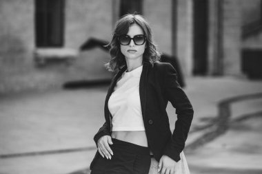 Modern iş binasının önünde başarılı bir iş kadınının portresi. Genç yönetici dışarıda poz veriyor. Ofisin kadın çalışanı..