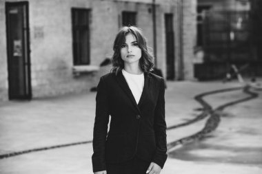 Modern iş binasının önünde başarılı bir iş kadınının portresi. Genç yönetici dışarıda poz veriyor. Ofisin kadın çalışanı..