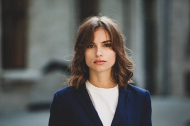 Modern iş binasının önünde başarılı bir iş kadınının portresi. Genç yönetici dışarıda poz veriyor. Ofisin kadın çalışanı..