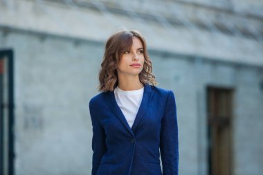 Modern iş binasının önünde başarılı bir iş kadınının portresi. Genç yönetici dışarıda poz veriyor. Ofisin kadın çalışanı..