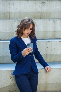 Modern iş binasının önünde başarılı bir iş kadınının portresi. Genç yönetici dışarıda poz veriyor. Ofisin kadın çalışanı..