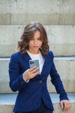 Modern iş binasının önünde başarılı bir iş kadınının portresi. Genç yönetici dışarıda poz veriyor. Ofisin kadın çalışanı..