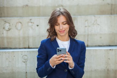Modern iş binasının önünde başarılı bir iş kadınının portresi. Genç yönetici dışarıda poz veriyor. Ofisin kadın çalışanı..