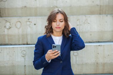 Modern iş binasının önünde başarılı bir iş kadınının portresi. Genç yönetici dışarıda poz veriyor. Ofisin kadın çalışanı..
