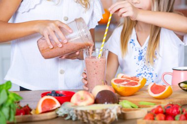 Mutfakta taze sebzelerle iki küçük kız. Sağlıklı gıda konsepti. Mutlu kardeşler..