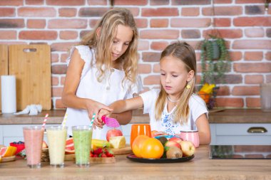 Mutfakta taze sebzelerle iki küçük kız. Sağlıklı gıda konsepti. Mutlu kardeşler..