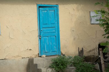Bir yaz günü köyde mavi boyalı bir evin eski ahşap kapısı.. 
