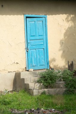 Bir yaz günü köyde mavi boyalı bir evin eski ahşap kapısı.. 
