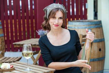 Güzel genç bir kadın bir restoranın terasında beyaz şarap içiyor. İşten sonra bir bardak şarapla dinleniyorum. Bekar kadın eğleniyor..