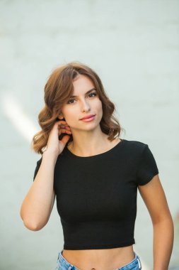 Uzun kahverengi saçlı ve kameraya gülümseyen güzel bir genç kadının portresi.
