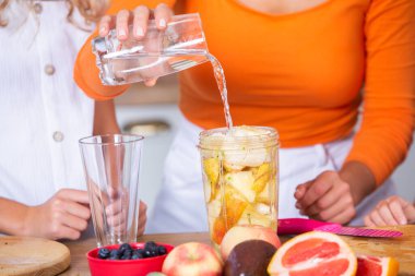 Mutlu anne ve kız mutfakta eğleniyorlar. Sağlıklı gıda konsepti.