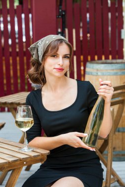 Güzel genç bir kadın bir restoranın terasında beyaz şarap içiyor. İşten sonra bir bardak şarapla dinleniyorum. Bekar kadın eğleniyor..