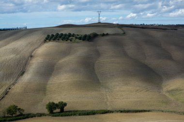 Tuscany, İtalya 'da hasat edilmiş tarlalar ve çayırlar. Sonbahar günbatımında dalgalı kır manzarası. Tarımsal mevsim için ekilebilir arazi hazır..