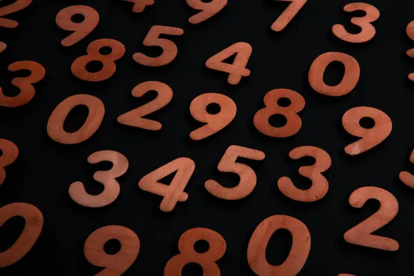 Wooden numbers on a black background. Numbers from zero to nine. Business success.